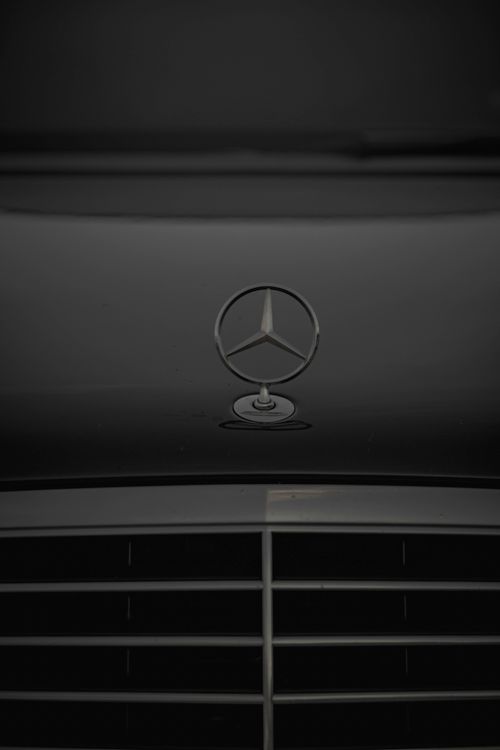 Free Black luxury car hood featuring a prominent emblem with sleek design. Stock Photo