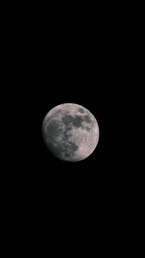 Free A detailed view of the full moon against a dark black background. Stock Photo