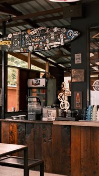 Surf-inspired bar interior with surfboard and sticker decor, offering a unique vibe.