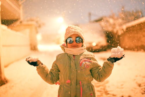 Girl in Sunglasses on Street in Snow at Night