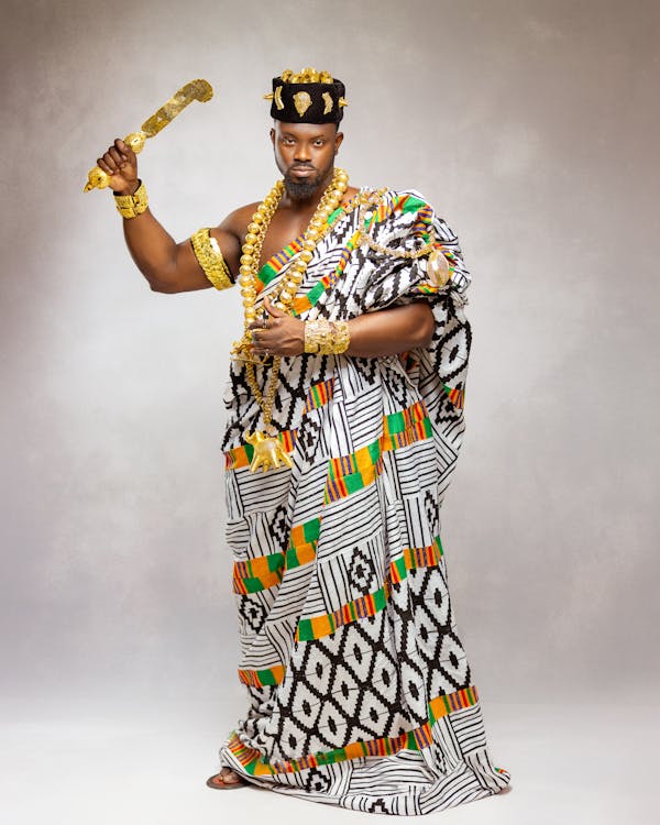 A man in an african outfit holding a sword · Free Stock Photo