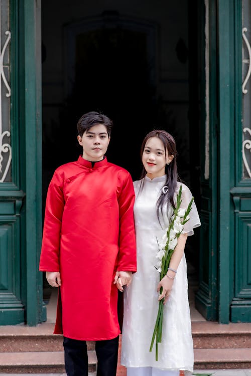 A man and woman in traditional clothing standing outside