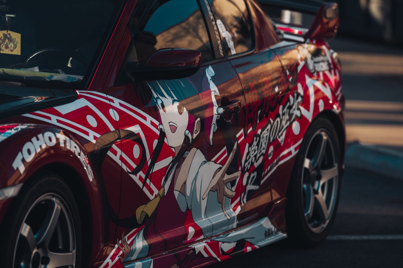 close up of a red sports car with bold anime themed custom livery show