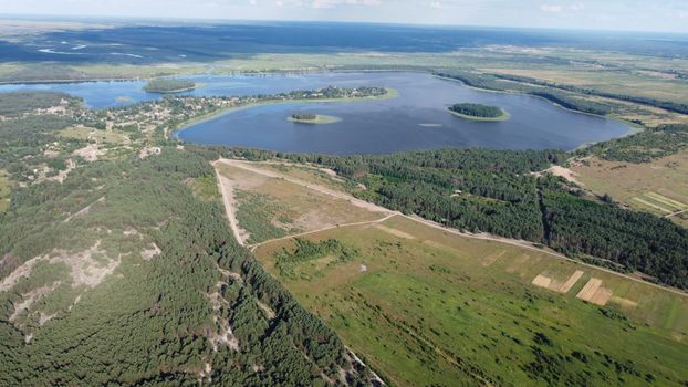 Stunning aerial view of a lake and forest in Mlyn, Ukraine, during summer.