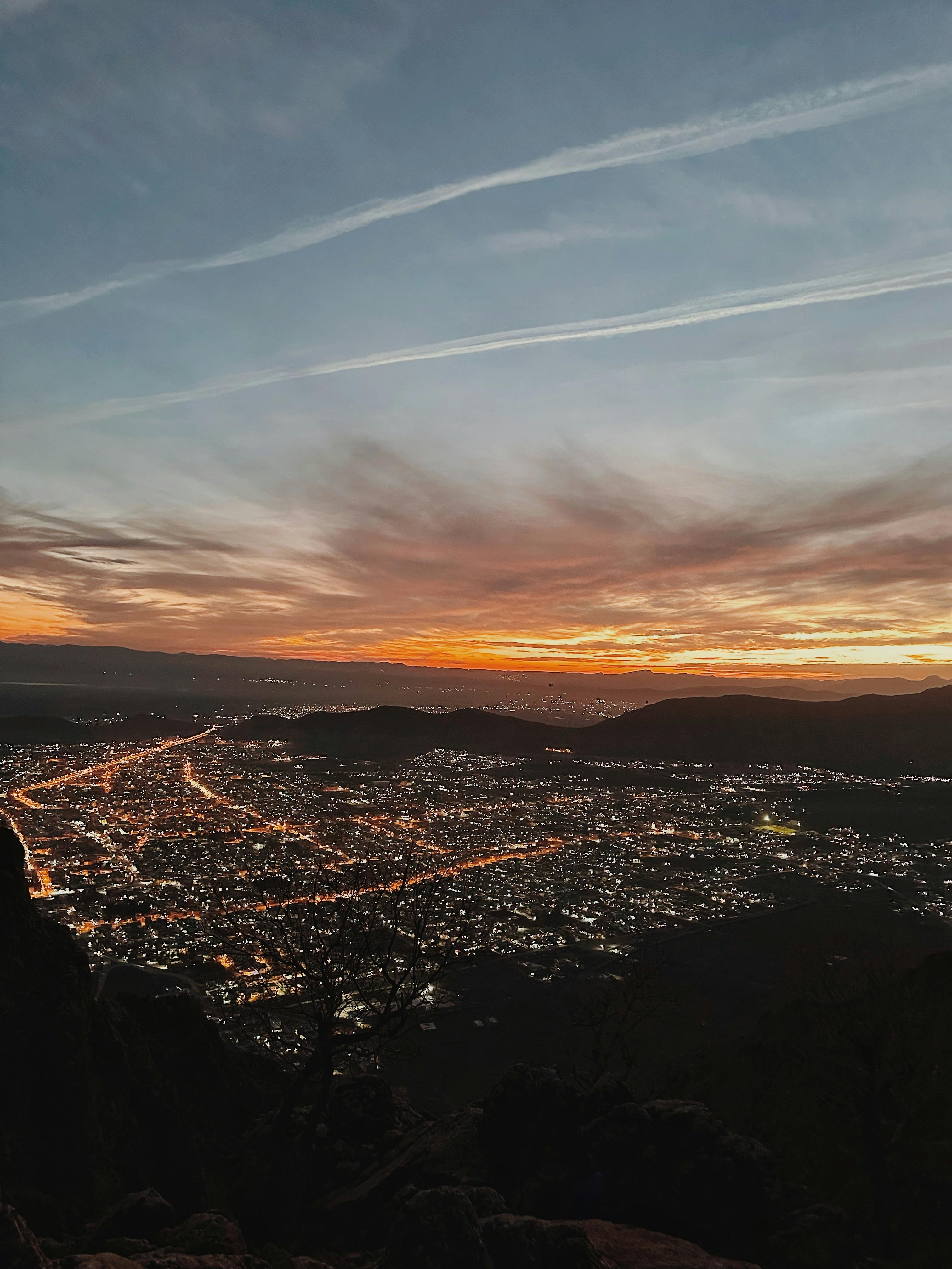 A breathtaking aerial view of Ranya, Iraq at sunset with illuminated city lights and distant mountains.