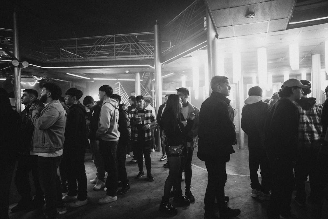Black and White Photo of People Gathered at a Party Outside 