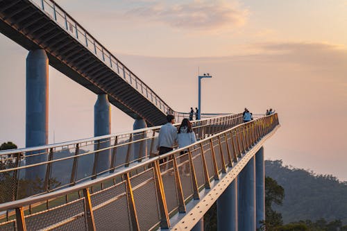 People Walking on Footbridge in City