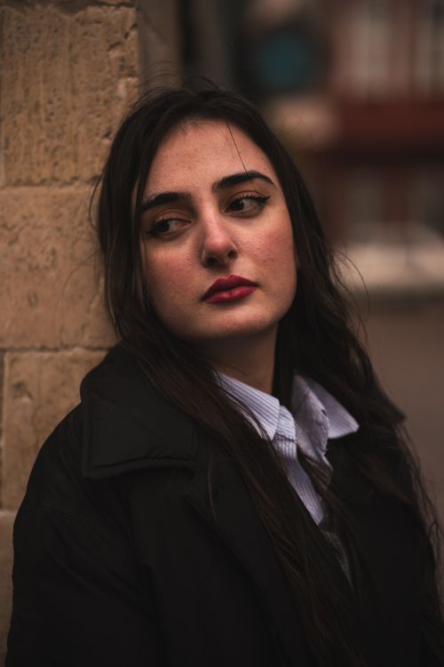 Free Close-up portrait of a woman with long black hair in an urban setting. Stock Photo