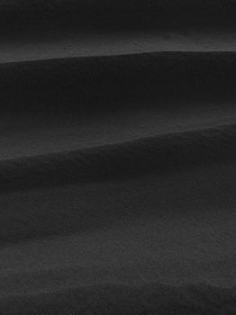 A close-up of black and white sand dunes, capturing natural patterns.