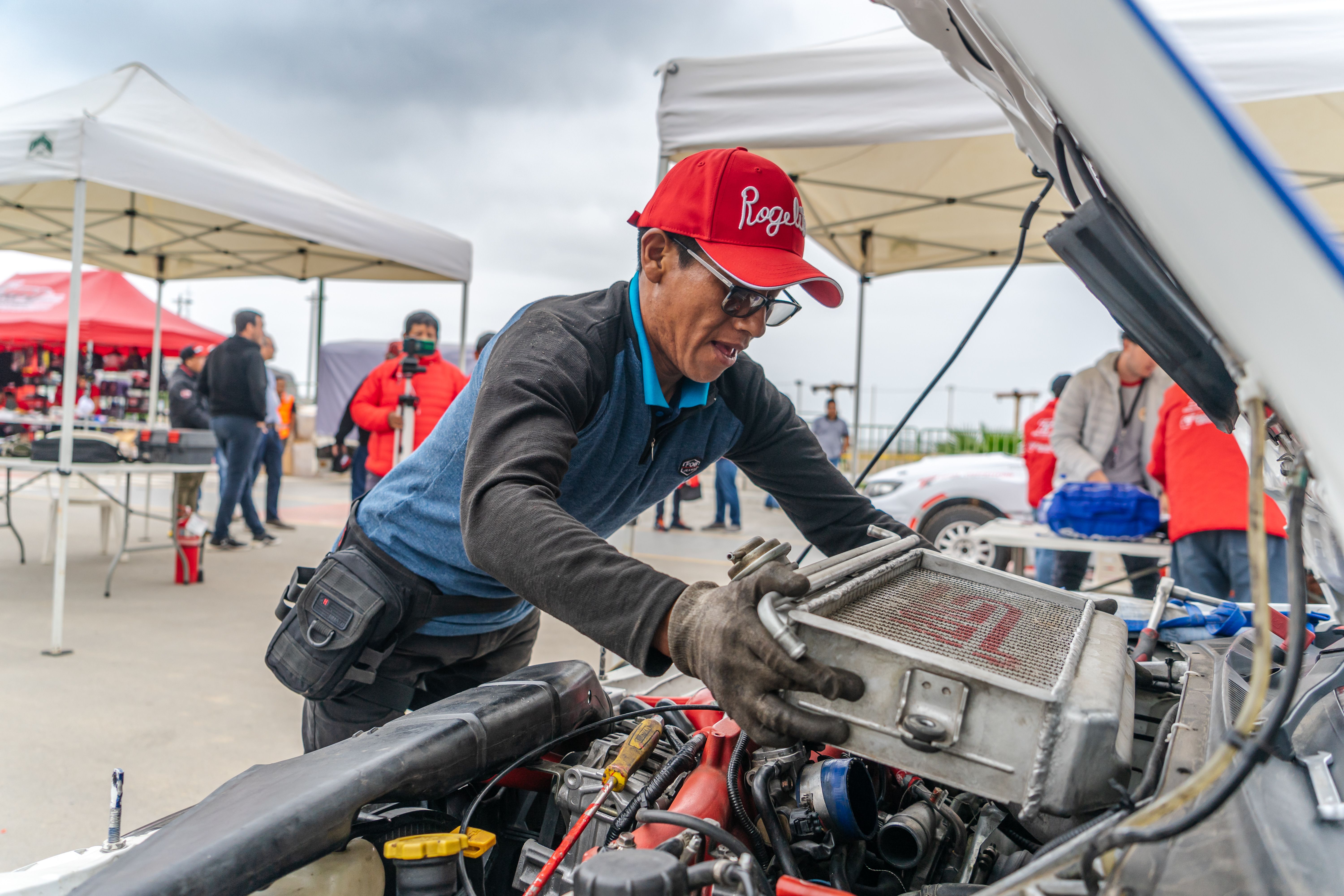 Mechanic Standing over Open Hood of Car · Free Stock Photo