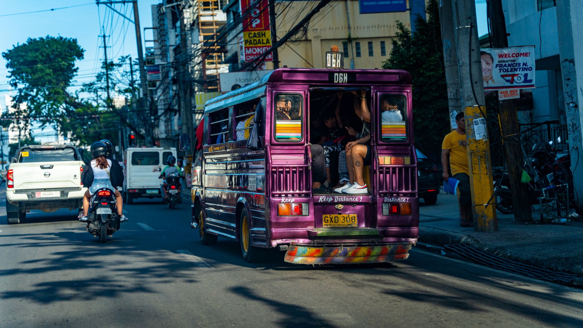 Busy urban street scene with a colorful jeepney and traffic in Cebu City, Philippines.