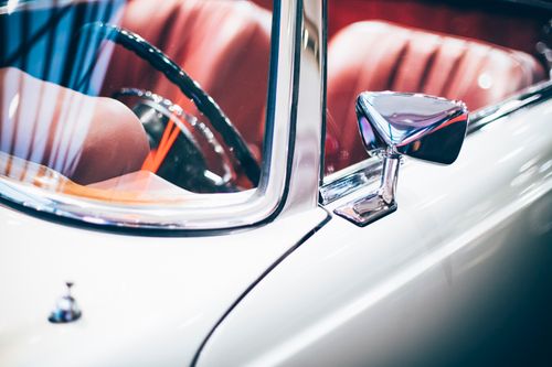 Free Elegant close-up view of a classic vintage car's side mirror and interior. Stock Photo