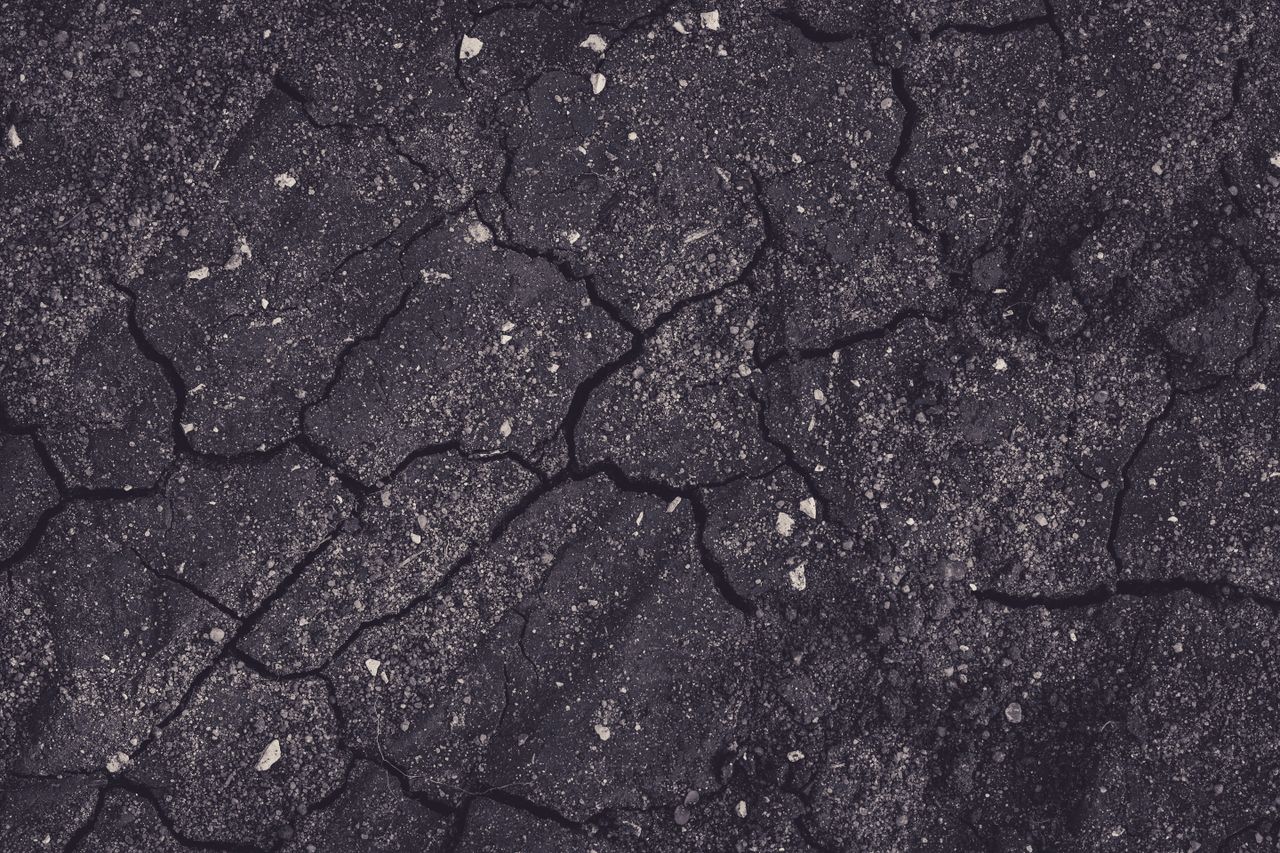 close up of cracked earth with dark tones showcasing natural textures