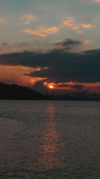 Serene sunset view at Gemlik Bay with vibrant clouds and silhouette of distant land.