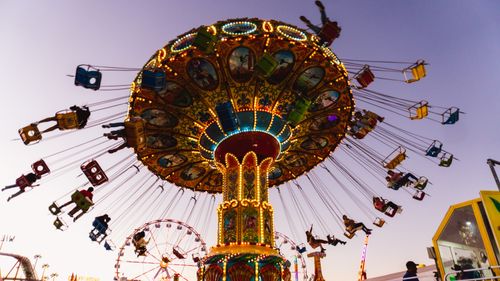 Free Enchanting carousel ride at sunset in León, capturing joyful moments and vibrant lights. Stock Photo