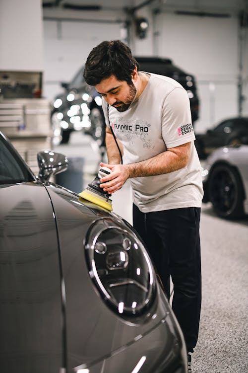 A man polishing a porsche car
