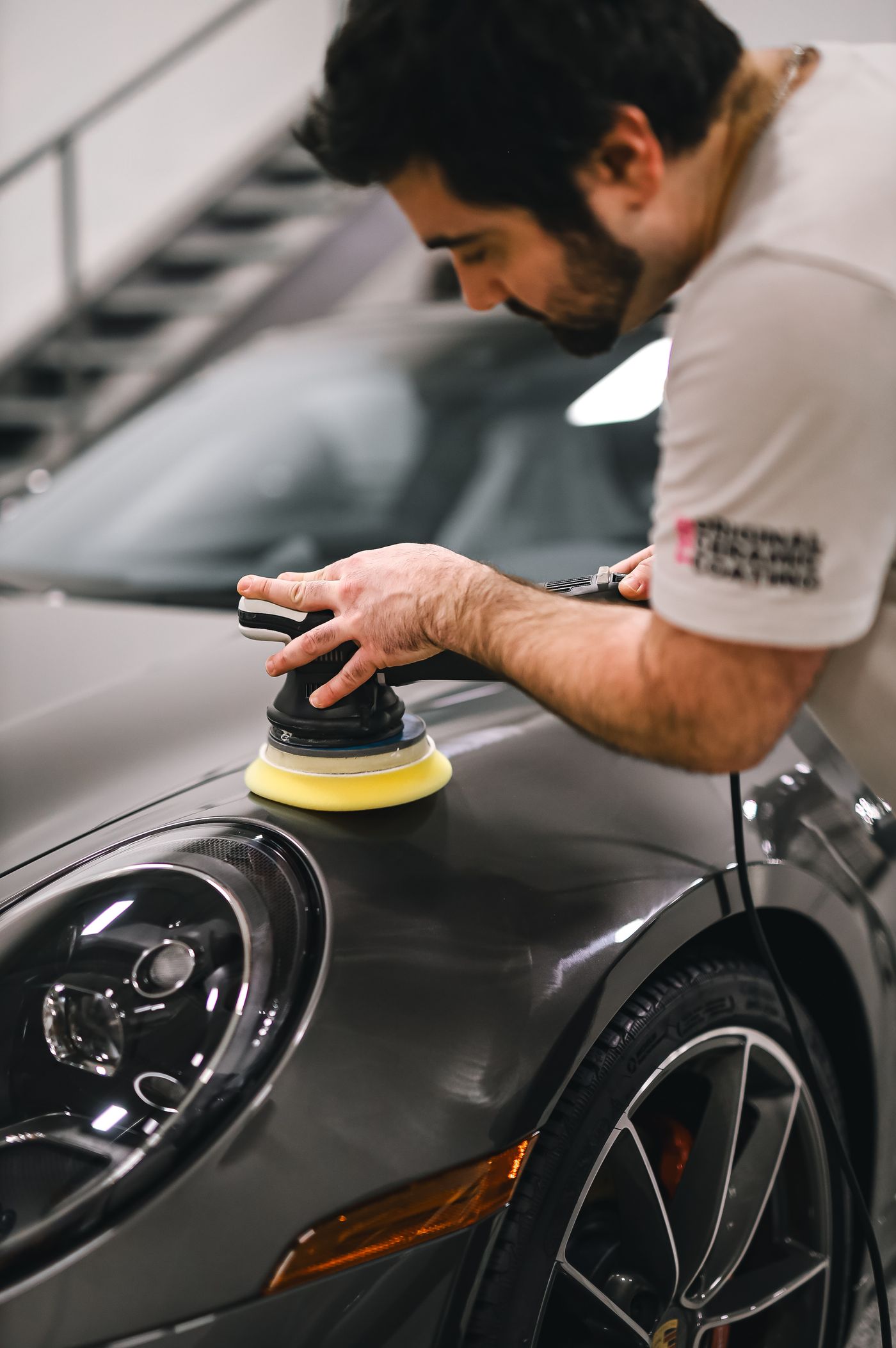Technicien polissant une voiture sport