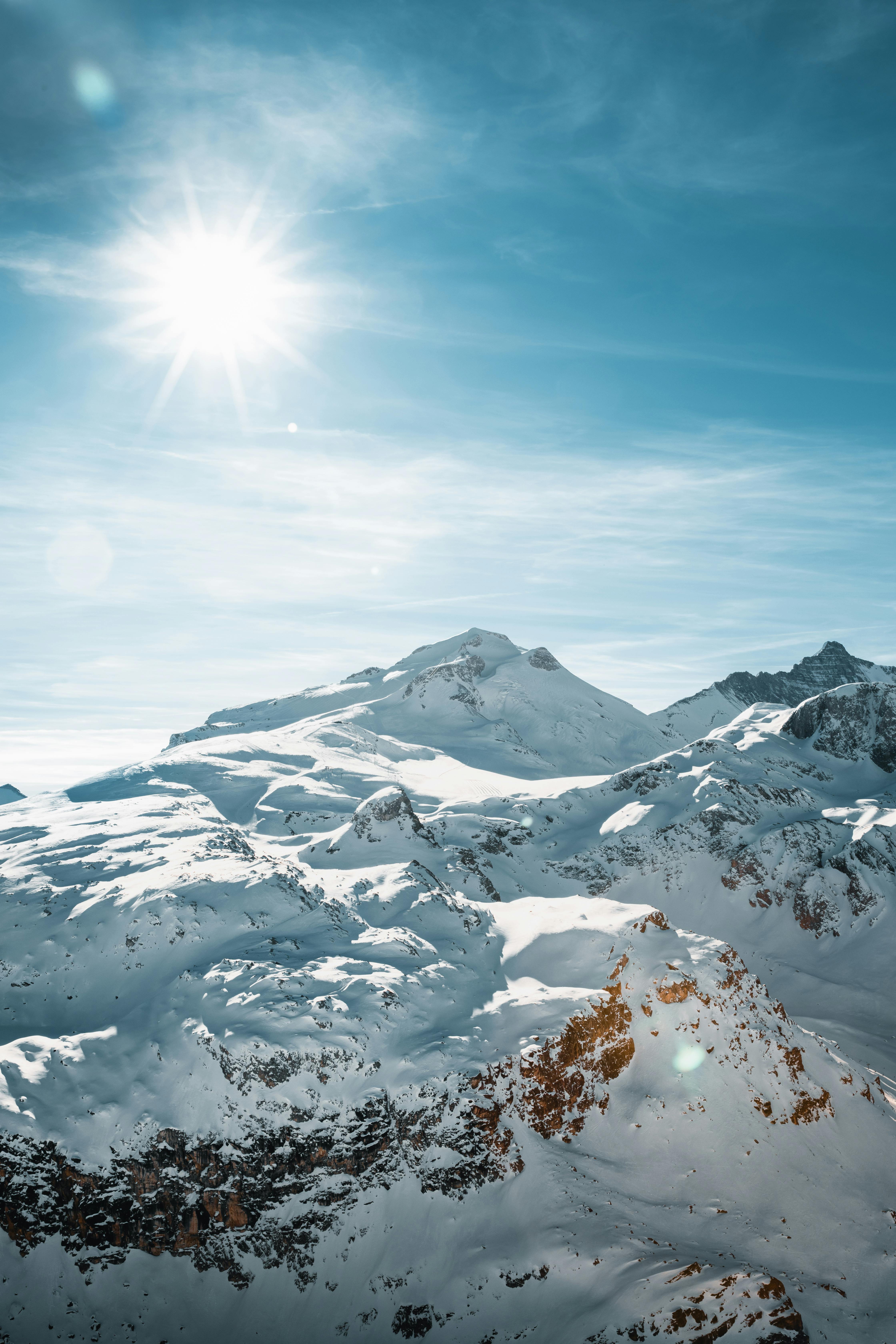 a snow covered mountain with the sun shining