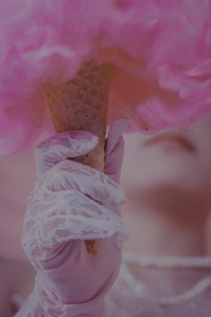 Close-up of a bride holding a cotton candy ice cream cone, featuring lace gloves for a whimsical touch.