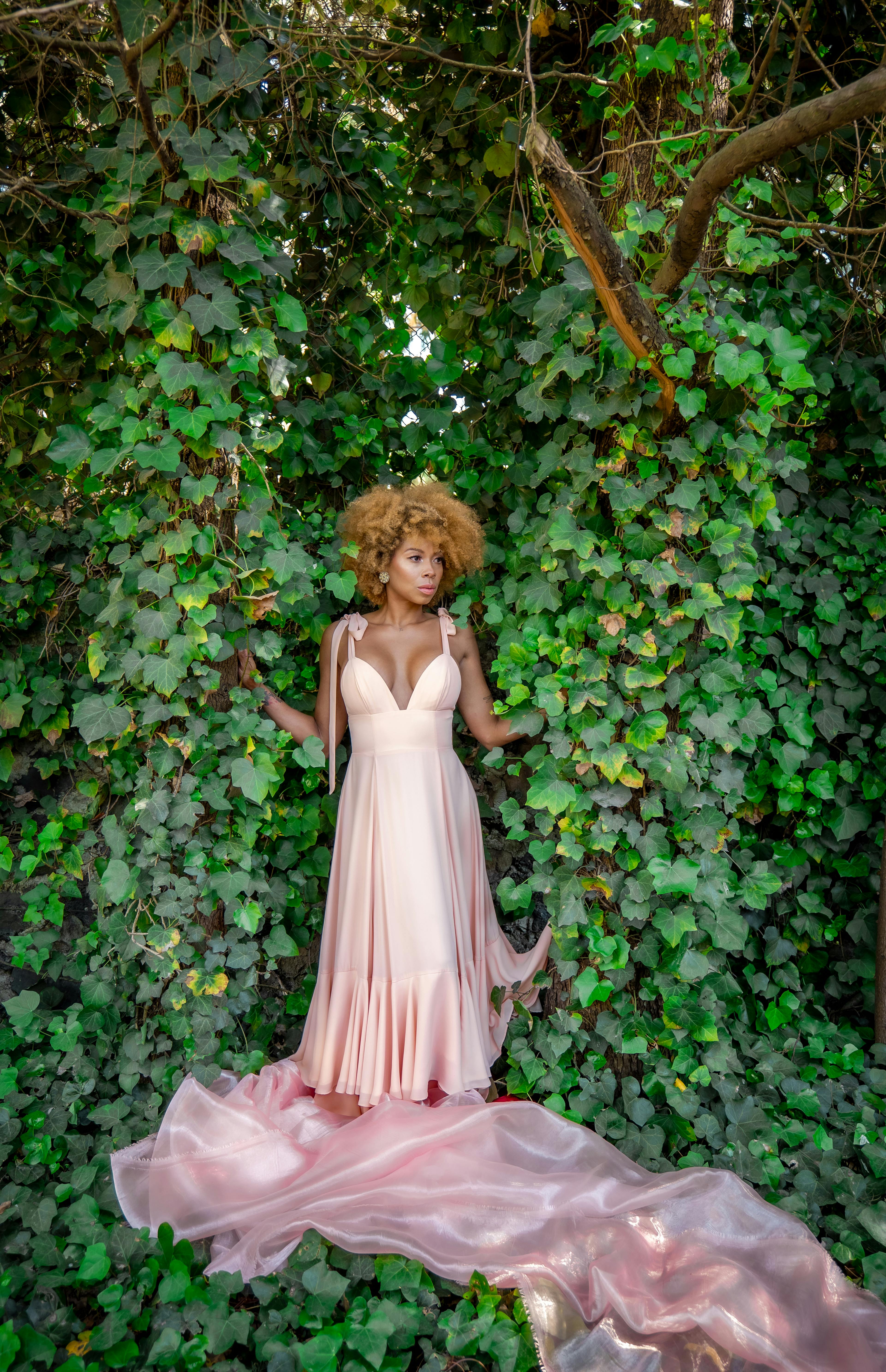 woman in a pink dress posing in a garden