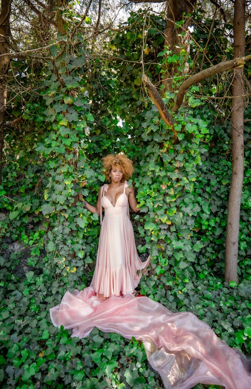 Woman in a Pink Dress Posing in a Garden 