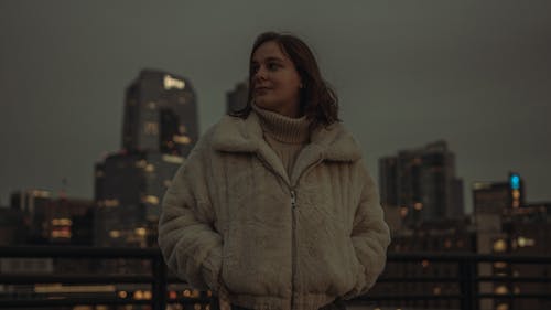 Brunette Woman in Jacket Against City Skyline