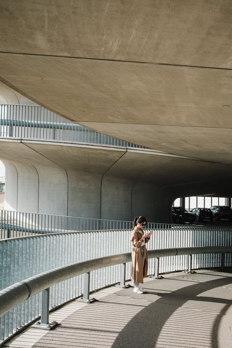 Woman Standing By Barrier And Railing