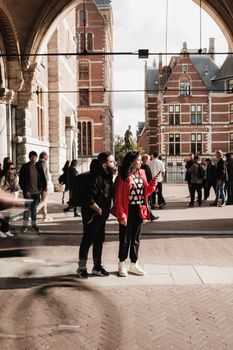 A couple of tourists stand and admire the architecture in Amsterdam's urban setting.