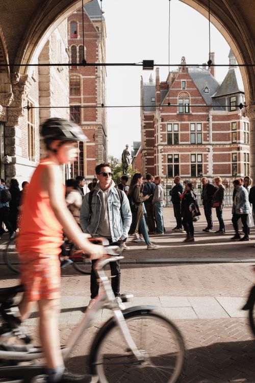 Free Vibrant urban scene in Amsterdam featuring cyclists and a bustling crowd. Stock Photo