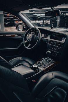 Elegant interior of a luxury car showcasing leather seats, steering wheel, and dashboard design.