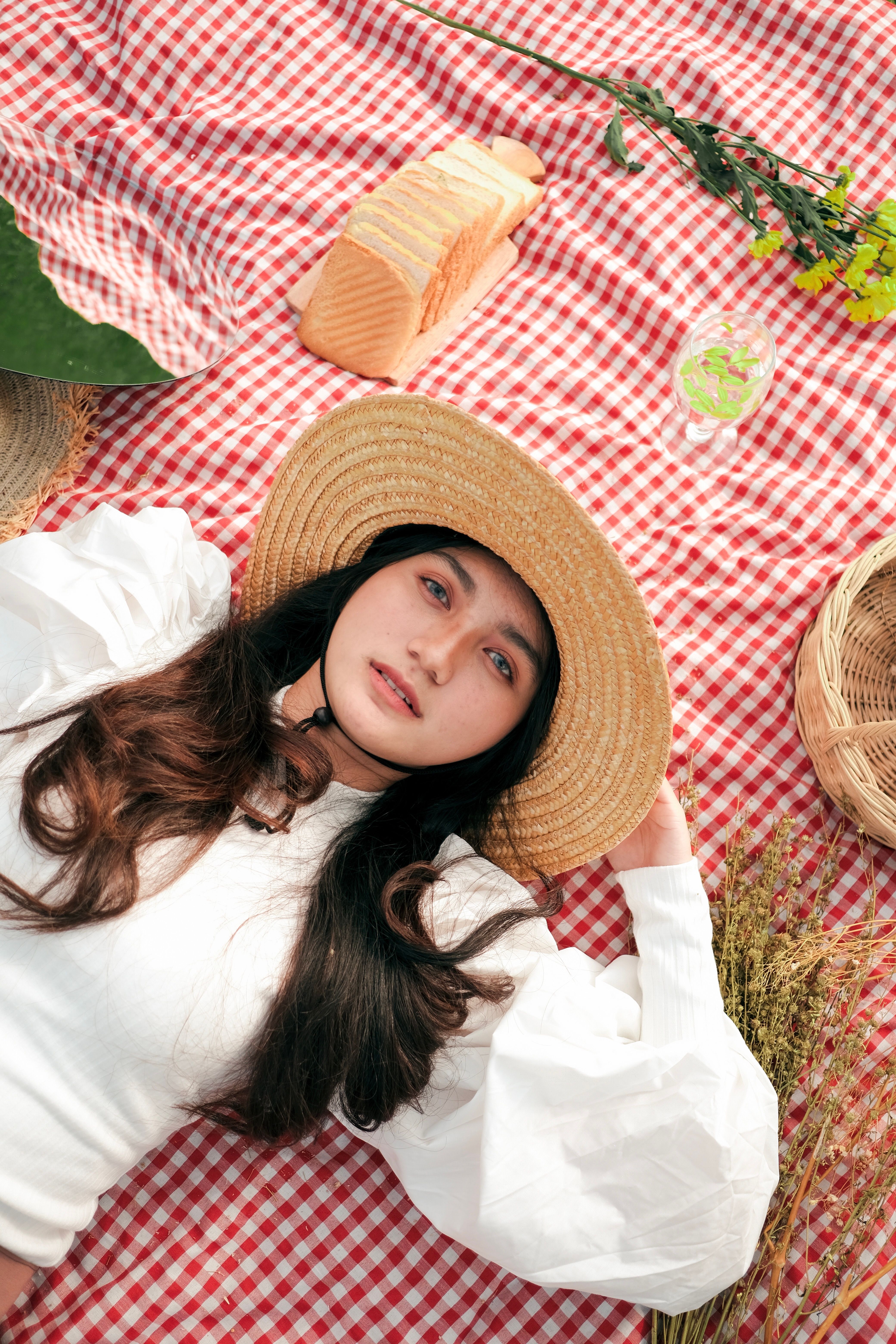 Young Woman in a Straw Hat and White Blouse Lying on a Plaid Picnic ...
