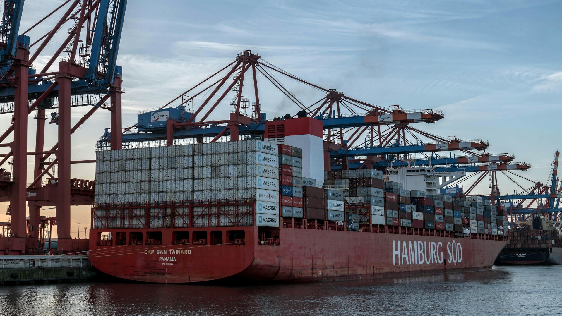 Massive container ship docked at Hamburg Port, showcasing logistics and global trade.