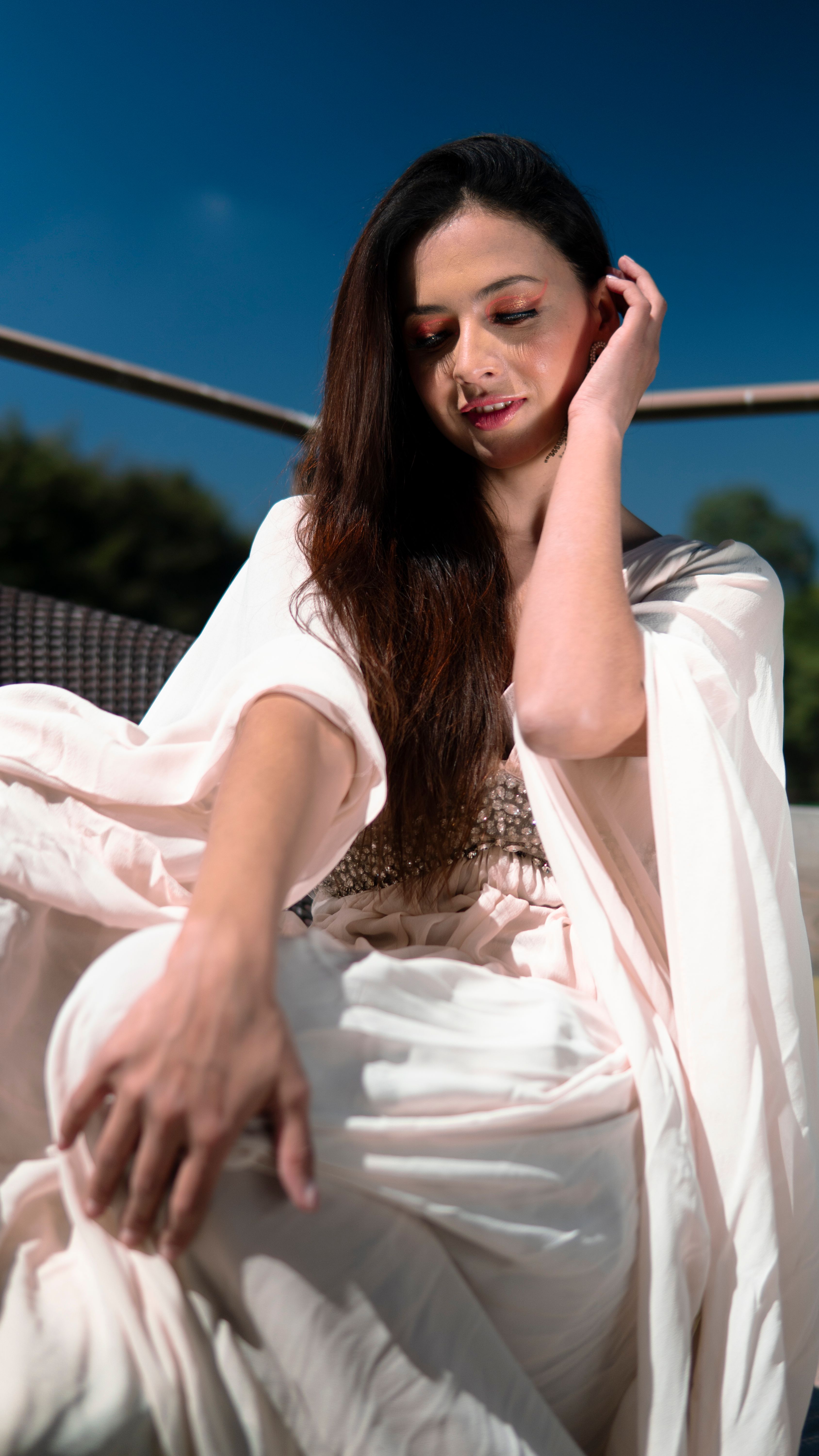 Portrait of a smiling woman in a white dress on a sunny day in Mexico City.