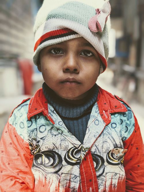 Free Adorable child bundled up in colorful winter clothing with a thoughtful expression. Stock Photo