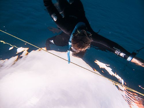 Free Close-up shot of a diver underwater, capturing movement in a serene sea setting. Stock Photo