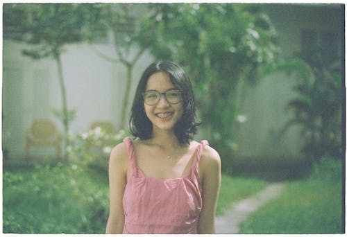A woman in a pink dress smiling at the camera