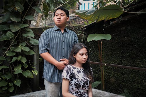 Man in Shirt Standing over Woman in Sundress