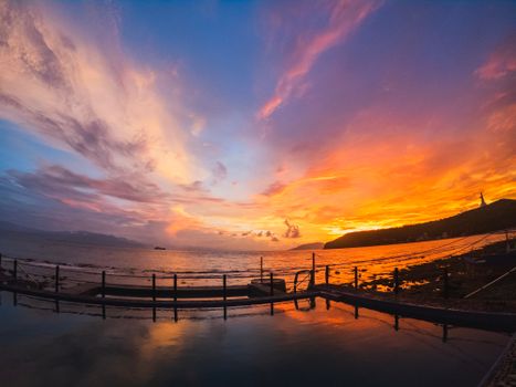 Stunning sunset colors reflect over a tranquil ocean view with dramatic sky.