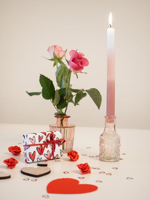 Romantic Valentine's Day setup with candles, roses, hearts and a present