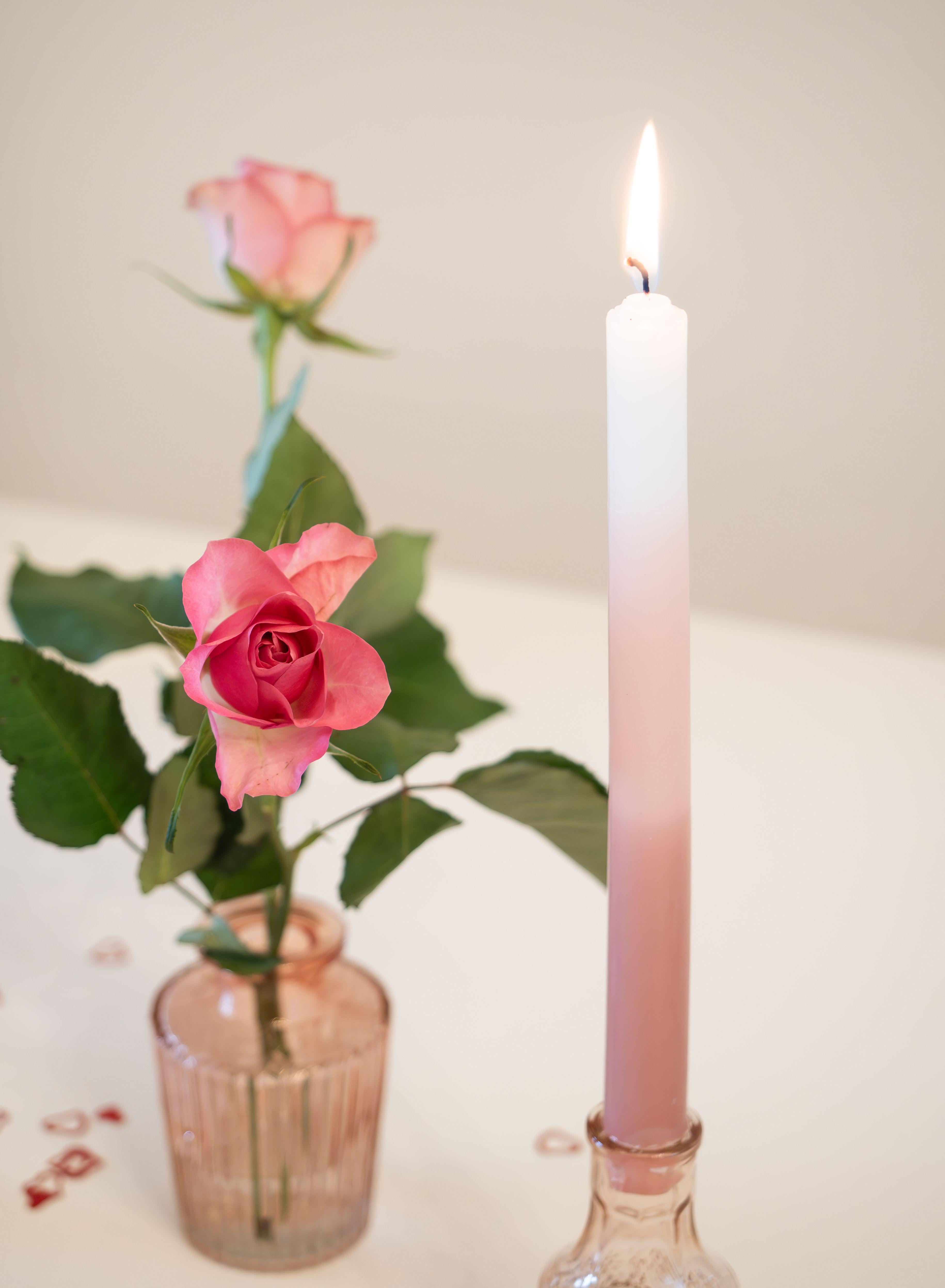 Pink rose and candle setting perfect for romantic celebrations or decor.