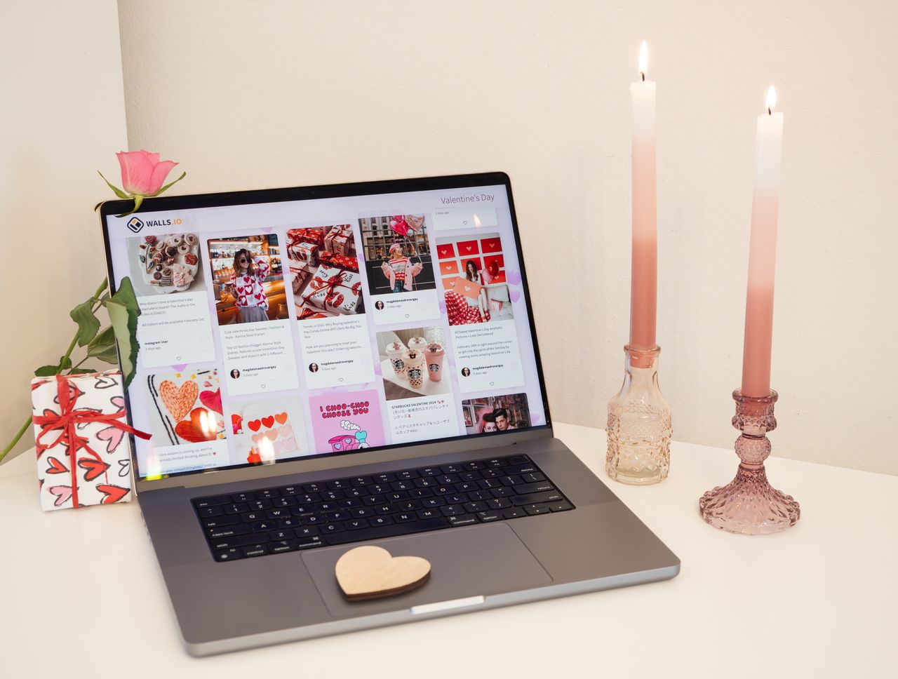 a cozy valentine s day themed laptop workspace with candles a gift and