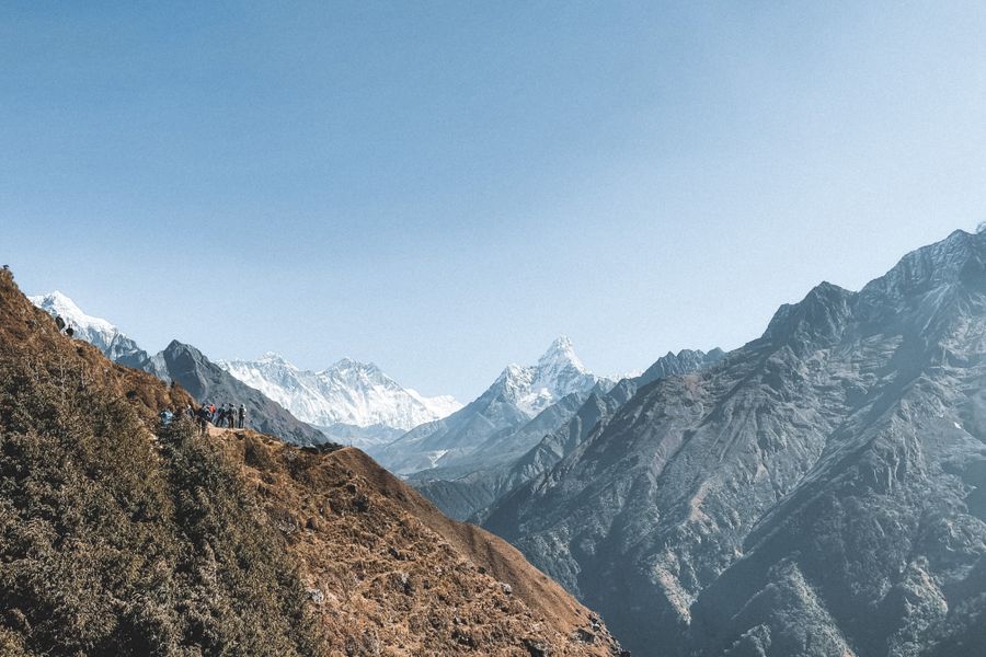 A stunning view of the Himalaya Mountains with hikers traversing the scenic mountain path in Nepal.