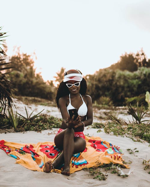 Woman in White and Red Bikini Holds Phone