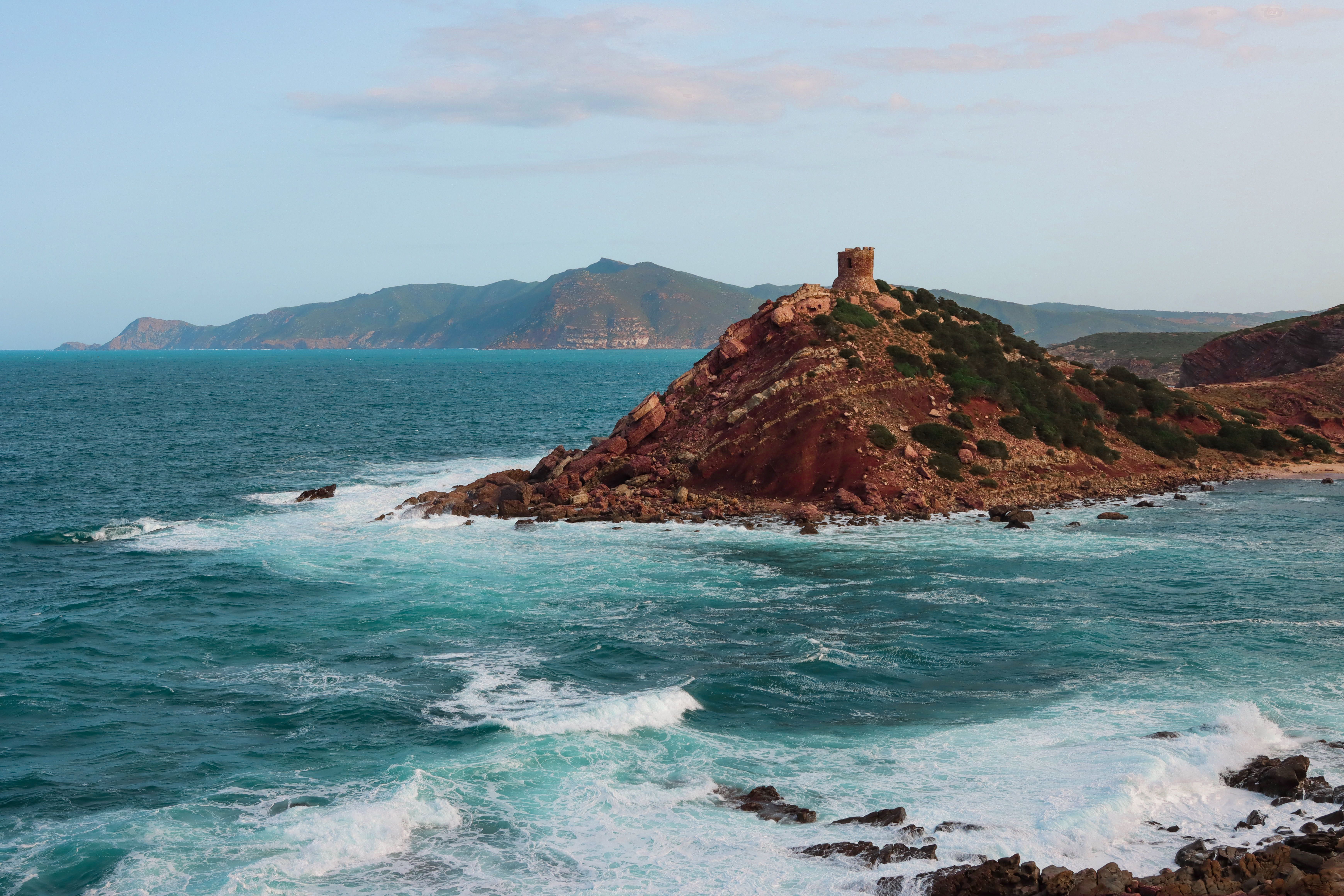 Beautiful seascape of Alghero coastline with waves crashing against rocky cliffs in Sardinia, Italy.