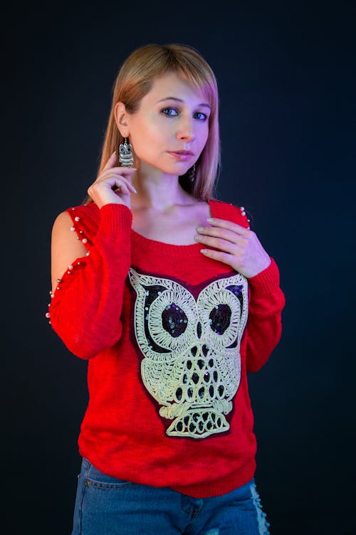 A woman in a red sweater with an owl on it