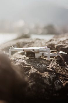 A drone positioned on rocks with blurred scenic background, capturing a serene moment.