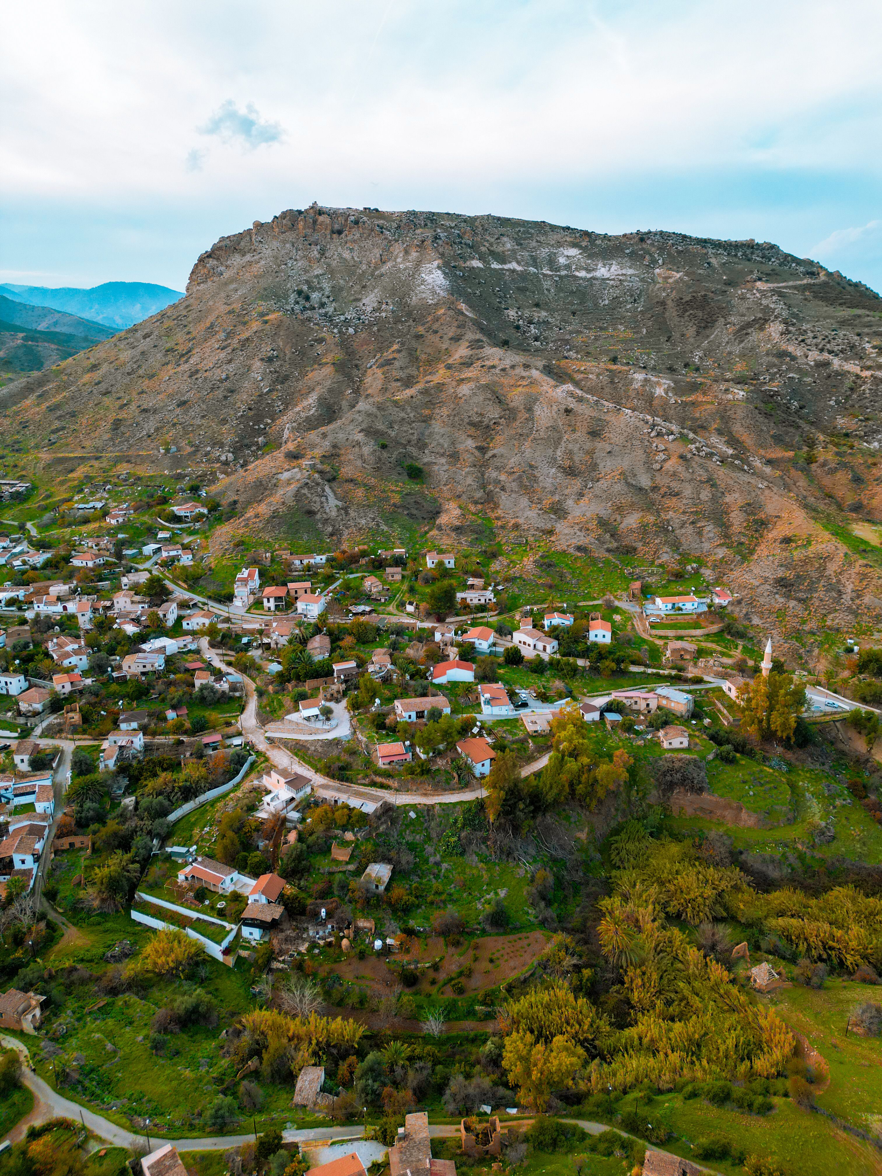 Charming aerial view of Bağlıköy village with hills and lush greenery, showcasing rural Cyprus beauty.
