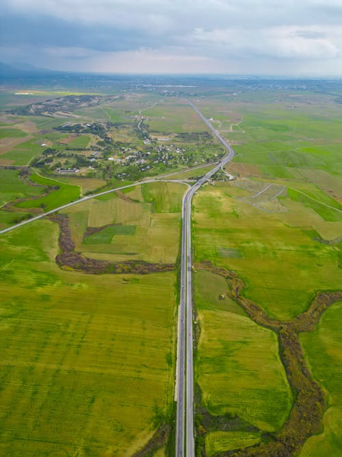Aerial View of a Road and Green Fields 