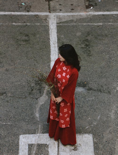 High Angle Shot of a Young Woman in a Traditional Red Dress with a Floral Pattern