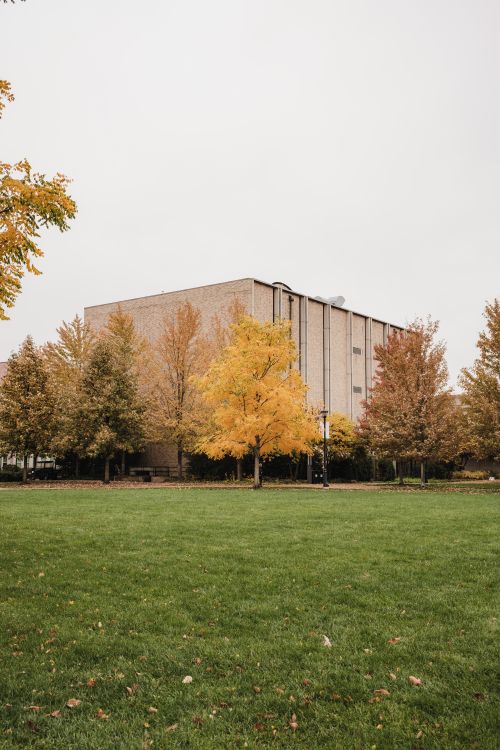 Free Autumn landscape of a university campus with brick building and colorful trees. Stock Photo